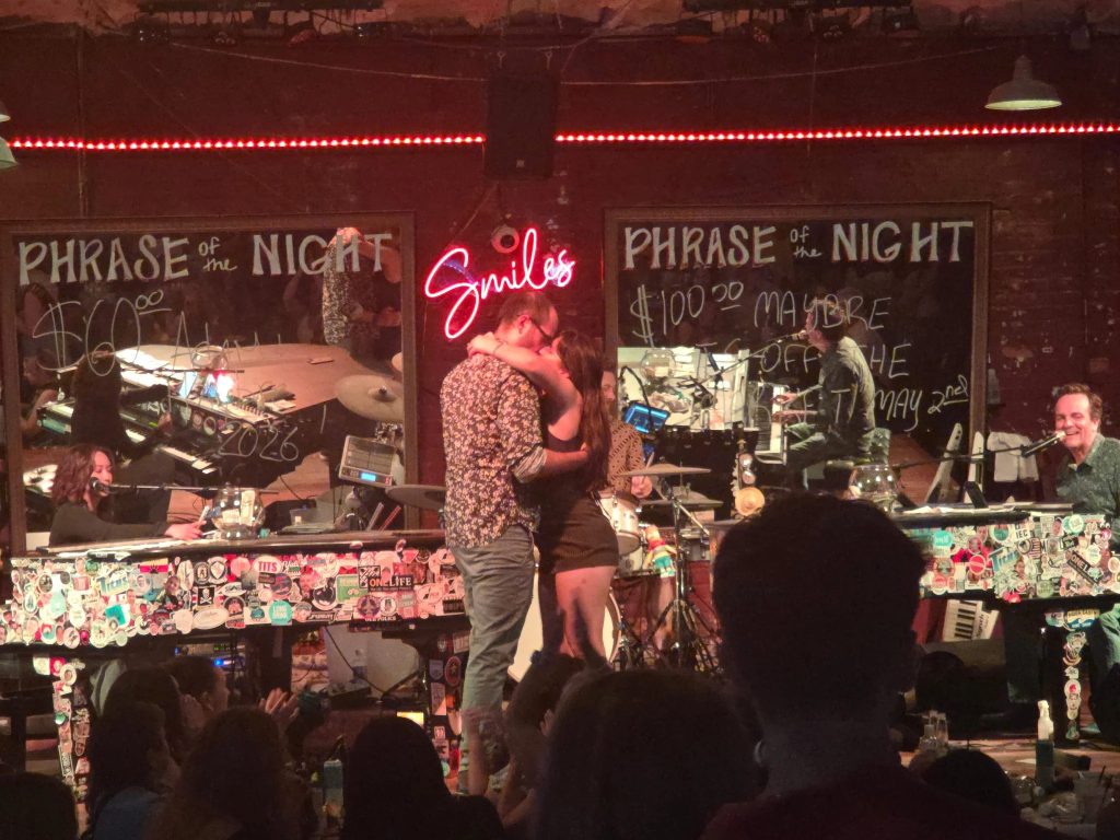 Dueling pianos under the neon Smiles sign