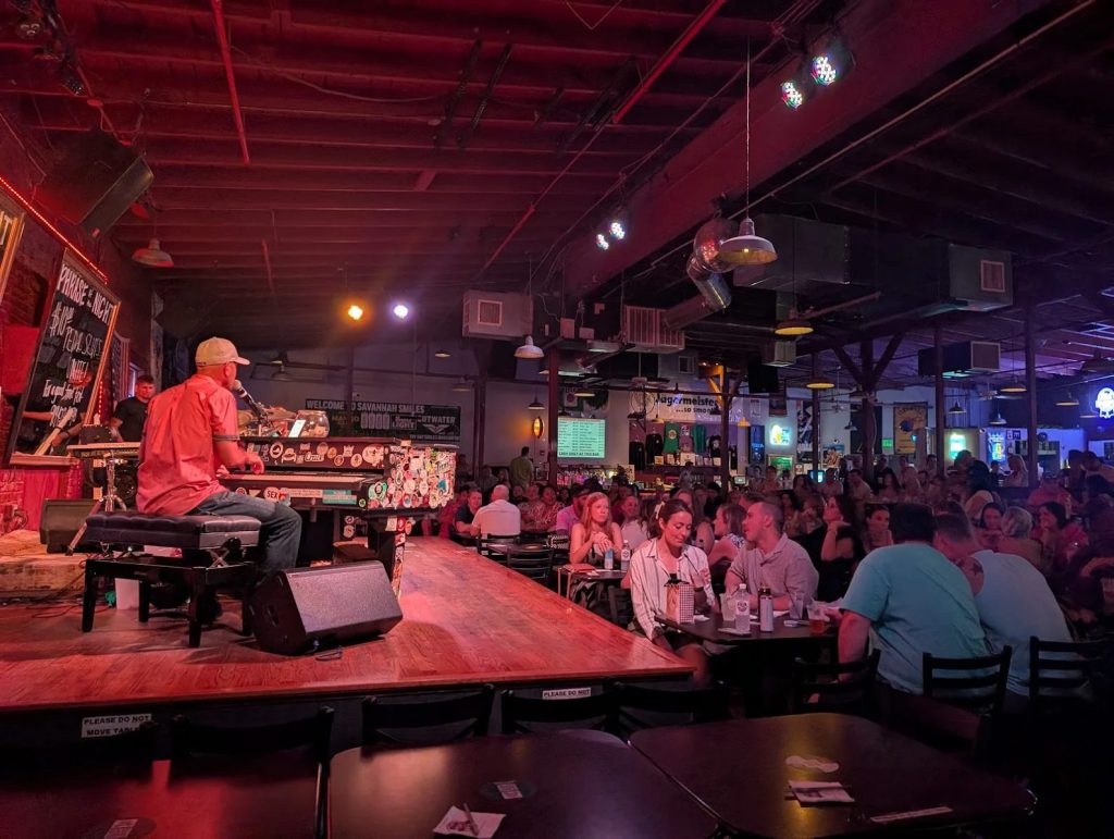 Piano player performing for a full room