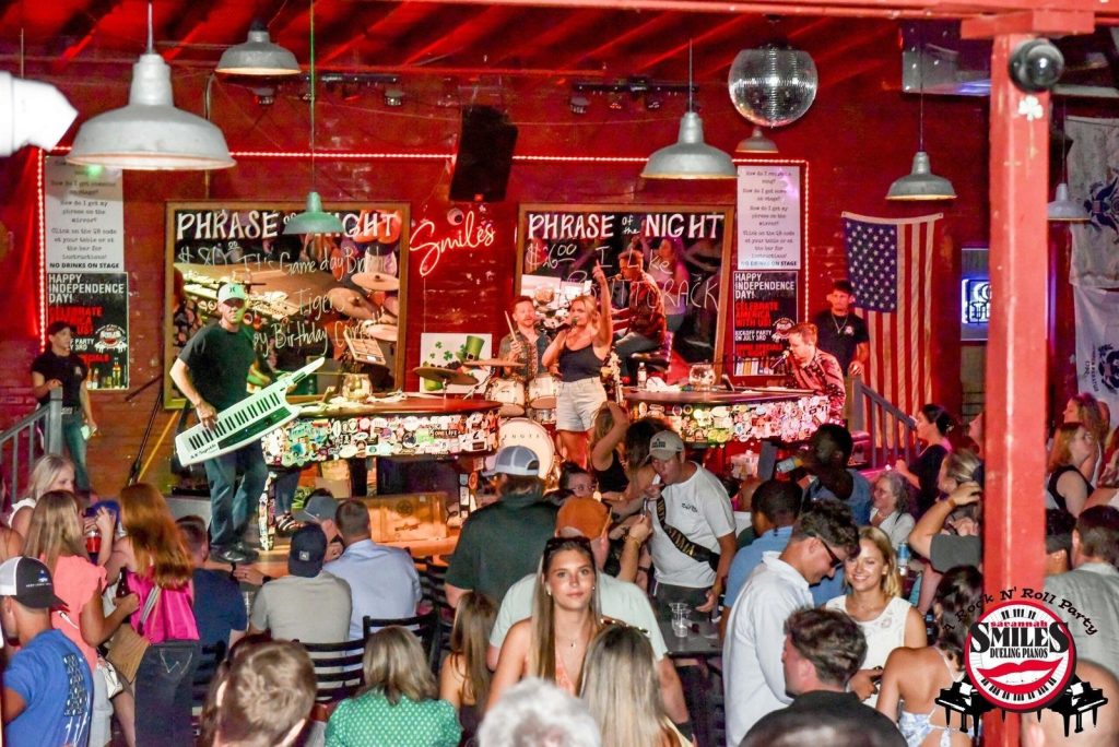 Full room watching the dueling pianos
