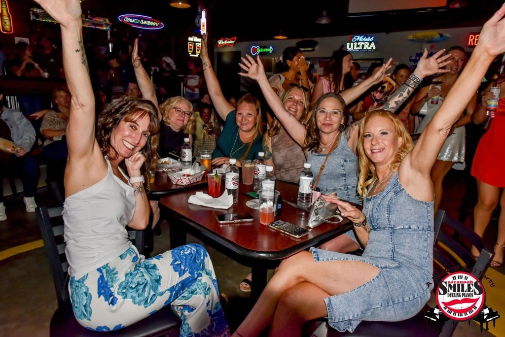 Table of guests with hands up